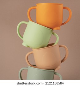 Modern colorful pastel silicone cups stacked in column on brown background. Baby tableware, first feeding, serving concept. Instagram use, square frame, levitation. - Shutterstock ID 2121138584