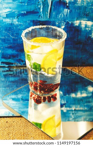 modern colorful urban close up photo of cool healthy cold party summer drink with fruits on blue background and mirror