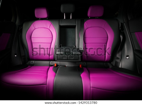 Modern comfortable race car pink red leather\
interior, backseats front\
view.