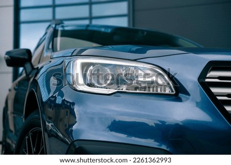 Modern compact SUV. Headlight of a modern luxury black car, auto detail,daytime running light.