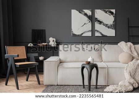 Modern composition of living room interior with mock up poster frame, modular sofa, black coffee table, beige plaid, round pillow, rattan armchair and personal accessories. Home decor. Template. 