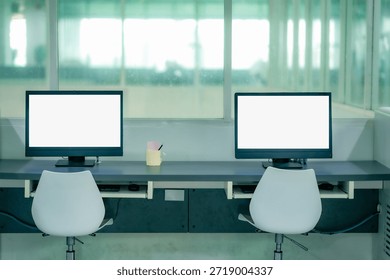 Modern computer desk setup inside library with empty chair screen showing digital study space academic research education technology learning environment.