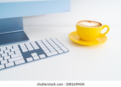 Modern computer desktop with yellow latte coffee cup on white table - Powered by Shutterstock