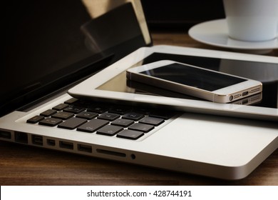 modern computer gadgets - laptop, tablet and phone close up, retro toned - Shutterstock ID 428744191