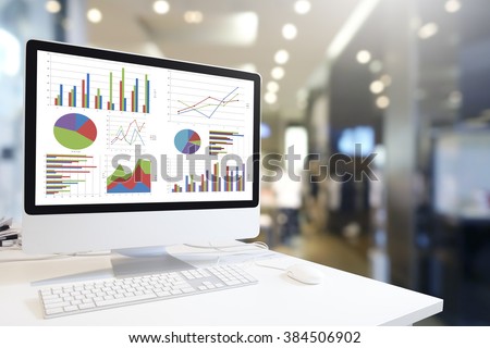Modern computer with keyboard and mouse on table showing charts and graph against office background in blue tone, Analysis Business, Statistics Concept.