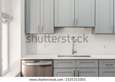Modern Condo Kitchen with Gray Cabinets and White Tile Backsplash and Empty Countertops