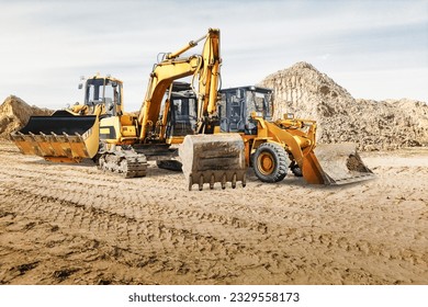 Modern construction machinery at a construction site in a quarry. Powerful modern equipment for earthworks. Rental of construction equipment. Excavator, dump truck, bulldozer, loader - Powered by Shutterstock