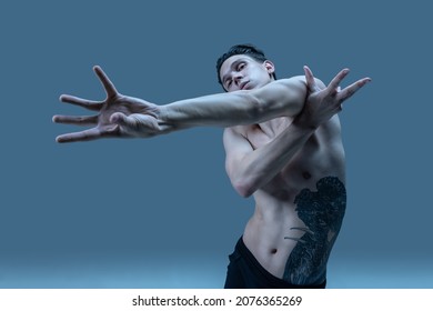 Modern, contemp. Close-up young artistic man, flexible male dancer dancing isolated on old navy studio background. Art, motion, flexibility, inspiration concept. Flexible artist. Beauty of male body - Powered by Shutterstock