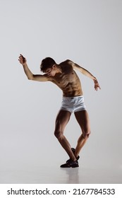 Modern, Contemp. Young Artistic Man, Flexible Male Dancer Dancing Isolated On Grey Studio Background. Art, Motion, Flexibility, Inspiration Concept. Flexible Artist. Beauty Of Male Body