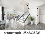 Modern contemporary home interior and exterior new construction professionally staged with simple clean furniture shades of grey and white soft colors white cabinets vinyl flooring windows to blue sky