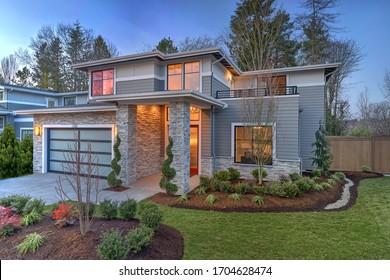 Modern Contemporary House Exterior With Luxury Details, Landscaping, Stone, Wood, Glass, Lots Of Large Windows With Evening Lights And Red Front Door.