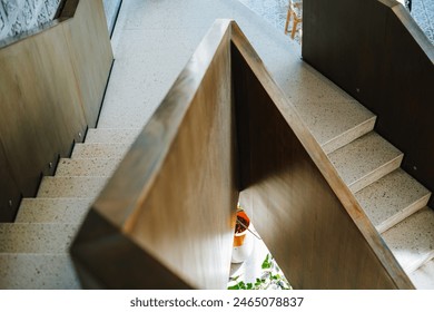 Modern contemporary and minimalist staircase with wooden railings and terrazzo floor. Blurred foreground and background. - Powered by Shutterstock