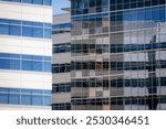 A modern contemporary office building with glass facade. Architectural detail of modern building. Business concept of successful industrial architecture. Corporate building in city.