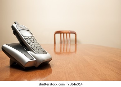 A Modern Cordless Phone Sits On An Empty Table