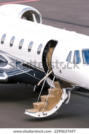 Modern corporate business jet on the tarmac of an airport.