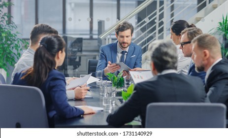 In The Modern Corporate Office Meeting Room: Diverse Group Of Businesspeople, Lawyers, Executives And Members Of The Board Of Directors Talking, Negotiating, Use Documents And Consult Statistic Graphs