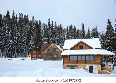 Moderne Hütten im schneebedeckten Nadelwald am Wintertag