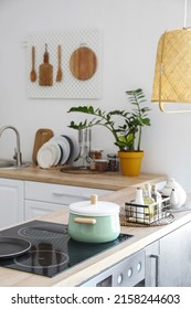 Modern Counters And Pegboard With Wooden Utensils In Light Kitchen