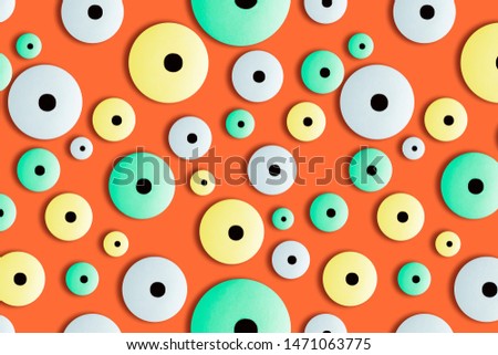 Modern creative seamless pattern of neon colors googly eyes candy on orange background.Photography collage.Funny children's treats.Halloween holiday concept.surrealism,pop-art style.Top view,flat lay