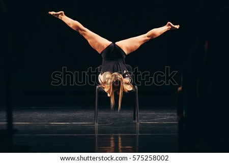 modern dancer performing handstand on a chair