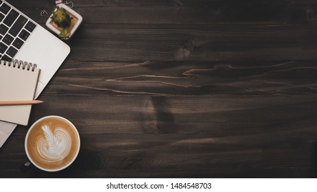 Modern Dark Wood Office Desk Table With Laptop, Smartphone And Other Supplies With Cup Of Coffee. Copy Space For Input The Text In The Middle. Top View, Flat Lay.