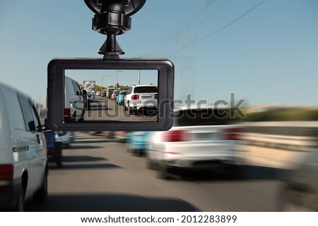Modern dashboard camera mounted in car, view of road during driving