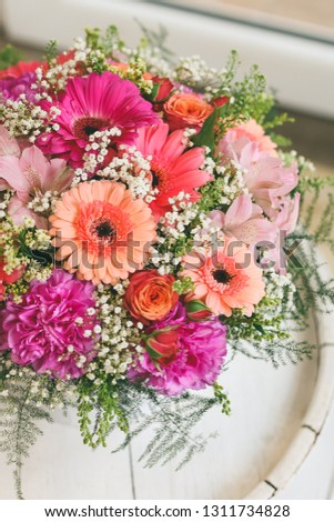 Modern and delicate bouquet of flowers in white round box. Beautiful floral arrangement in a hat box. Flowers bouquet in headbox. Young happy arrangement, a beautiful bunch of pink flowers.