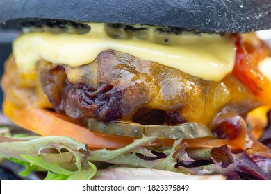 Modern Delicious Black Burger With Meat, Bun, Lettuce, Cheese, Ketchup. Funk Food Concept. Macro. Selective Focus