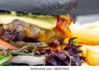 Modern Delicious Black Burger With Meat, Bun, Lettuce, Cheese, Ketchup. Funk Food Concept. Macro. Selective Focus