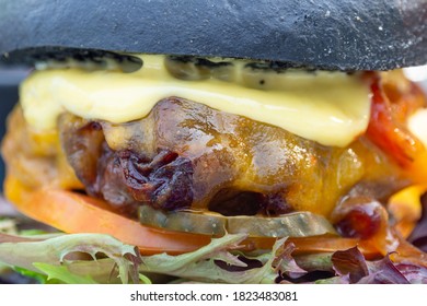 Modern Delicious Black Burger With Meat, Bun, Lettuce, Cheese, Ketchup. Funk Food Concept. Macro