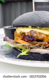 Modern Delicious Black Burger With Meat, Bun, Lettuce, Cheese, Ketchup. Funk Food Concept