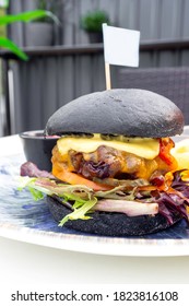 Modern Delicious Black Burger With Meat, Bun, Lettuce, Cheese, Ketchup. Funk Food Concept