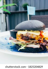 Modern Delicious Black Burger With Meat, Bun, Lettuce, Cheese, Ketchup. Funk Food Concept