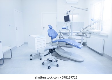 Modern dental practice. Dental chair and other accessories used by dentists in blue, medic light - Shutterstock ID 398189713