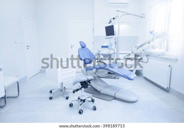 Modern dental practice.\
Dental chair and other accessories used by dentists in blue, medic\
light
