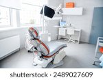 Modern dentist office with a dental chair, workstation, and medical tools in a bright, clean environment.