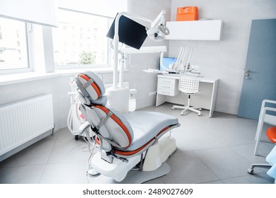 Modern dentist office with a dental chair, workstation, and medical tools in a bright, clean environment. - Powered by Shutterstock