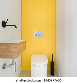 Modern Design Bathroom Interior With Black Tap In Small Washbasin And White Toilet With Rectangular Yellow Wall Tiles Behind It