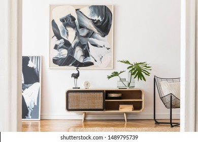 Modern design home interior of living room with wooden commode, design black armchair, tropical leafs and elegant accessories. Stylish home decor. Mock up abstract paintings on the wall. Template. - Shutterstock ID 1489795739