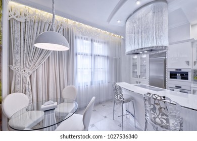 Modern design interior with white glossy kitchen in a luxurious apartment in gray and white tones.