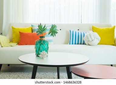 Modernes Design des Wohnzimmers mit gelbem, blauem und orangefarbenem Kissen auf dem Sofa. Modernes Küstenhaus-Interieur.