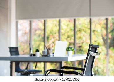 Modern design office room with couple of chairs and 1 table and pencil, notebook, small vase, pen, and coffee cup on table, Nature outside window background