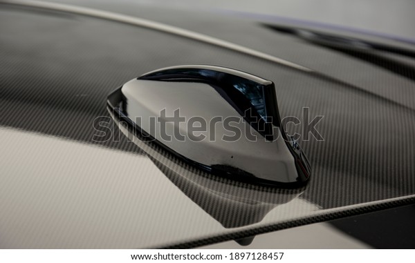 Modern design sport car radio antenna on the\
carbon roof also known as shark\
fin.
