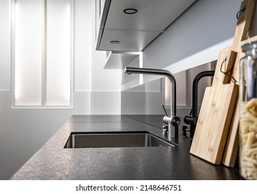 Modern Designer Chrome Water Tap Over Stainless Steel Kitchen Sink Close Up.