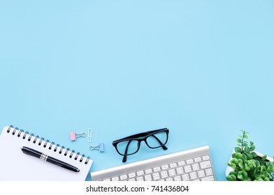 Modern Desk Business Working Place With Glasses,keyboard Computer,Pen And Notebook On Table Workspace Top View With Space For Your Text.
