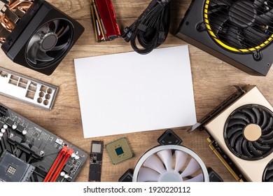 Modern Desktop Computer Hardware Components On Wood Desk Table With Blank Copy Space Paper Background. Circle Shaped Pc Parts Like Cpu Motherboard Graphics Card And Ssd Wood Technology Concept.