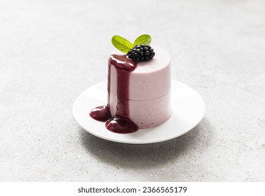 Modern dessert. Blackberry cream pudding, Panna Cotta with blackberry sauce,  cylindrical shape. Light background. Close up - Shutterstock ID 2366565179