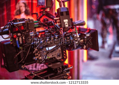 A modern digital filmtv camera stands at the ready on set.