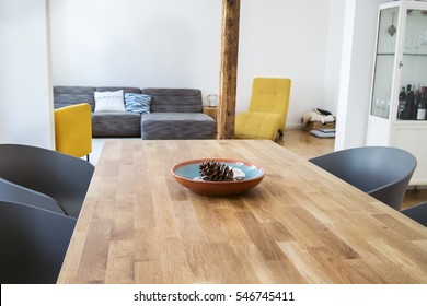 Modern Dining Table In An Open Plan Living Room With Tub Chairs On Either Side And A View Through To A Comfortable Seating Area Behind