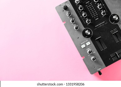 Modern DJ mixer on color background